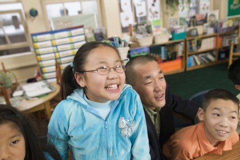 Asian children and father in classroom