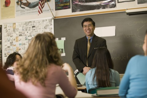 Asian teacher talking to students in classroom