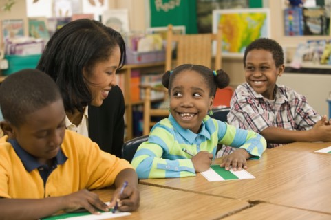 African school teacher helping students
