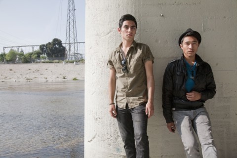 Serious teenage boys leaning against wall