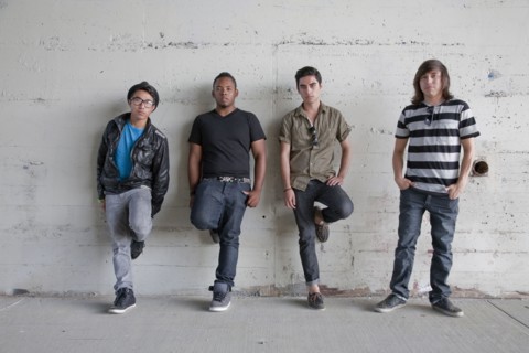 Serious teenage boys leaning against wall