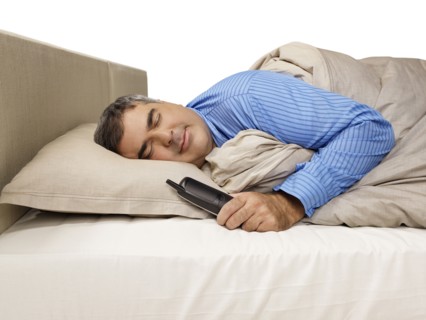 Caucasian man sleeping and holding telephone