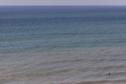 Aerial view of surfer floating on ocean waves