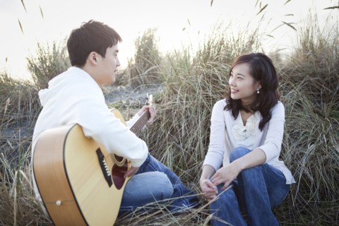 Korean man playing guitar for girlfriend