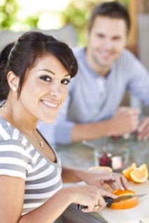 Hispanic woman slicing oranges on patio