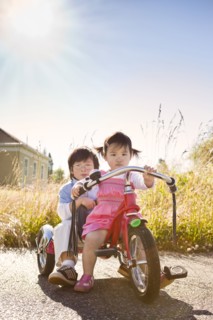 Chinese brother and sister riding tricycle