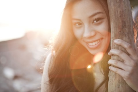Chinese woman leaning on tree trunk