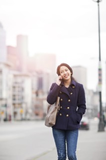 Mixed race woman walking and talking on cell phone