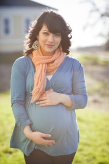 Pregnant mixed race woman holding stomach