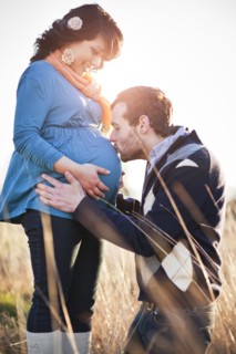 Husband kissing pregnant woman's stomach