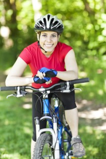 Hispanic woman riding mountain bike in forest