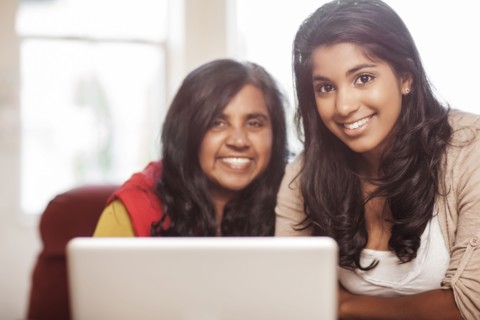 Indian mother and daughter using laptop together