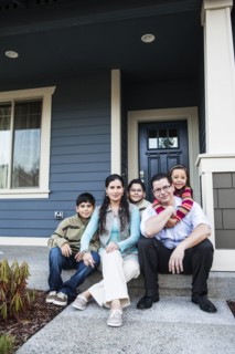 Family smiling on front stoop