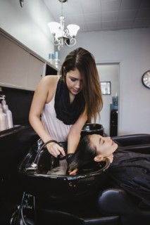 Stylist washing client's hair in salon