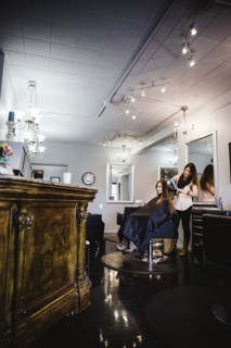 Stylist brushing client's hair in salon