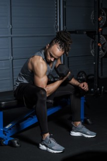 Mixed Race man lifting weights in gymnasium