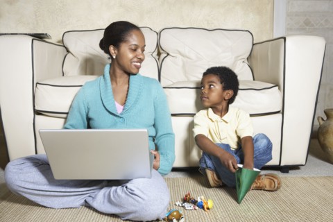 African American mother sitting with son and laptop