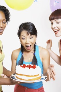 Asian woman being surprised with cake