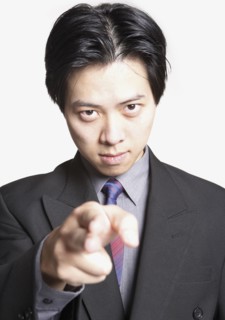 Studio shot of Asian businessman pointing finger