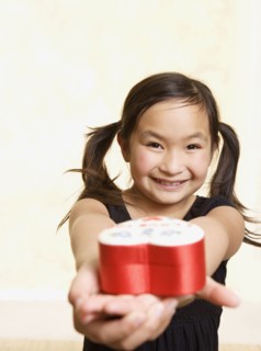 Young Asian girl with heart box in outstretched hands