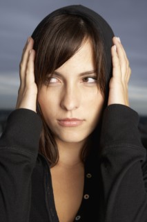Hispanic woman covering ears with hands