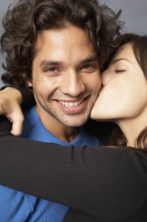 Hispanic woman hugging and kissing boyfriend
