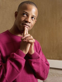 African man touching fingers to chin