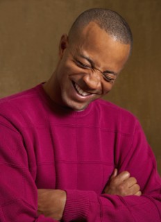 African man laughing with arms crossed