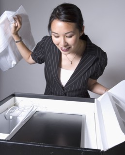 Asian businesswoman opening box with new computer