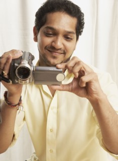 Indian man holding video camera