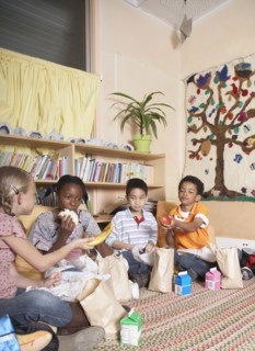 Multi-ethnic school children eating lunch