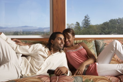 Multi-ethnic couple sitting on sofa