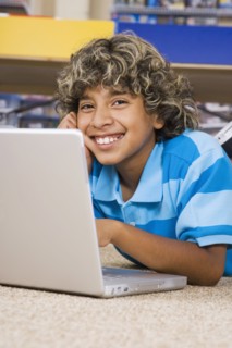 Hispanic boy typing on laptop
