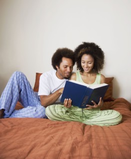 African couple reading in bed