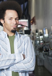 Mixed Race male hair stylist with arms crossed