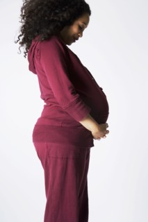 Pregnant Mixed Race woman looking at belly