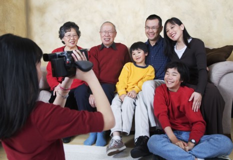 Multi-generational Asian family being video recorded