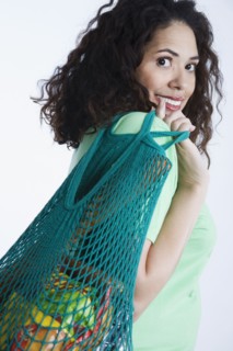 Mixed race woman holding reusable grocery bag