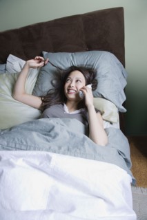 Woman talking on phone in bed
