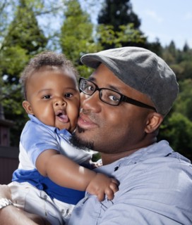 African American man cheek to cheek with baby son