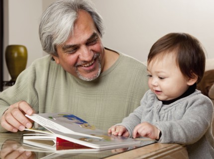 Grandfather reading book to granddaughter