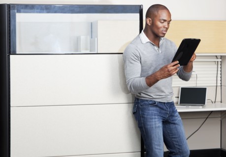 Mixed race businessman using digital tablet in office