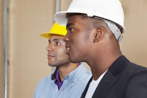 Mixed race businessmen in hard hats