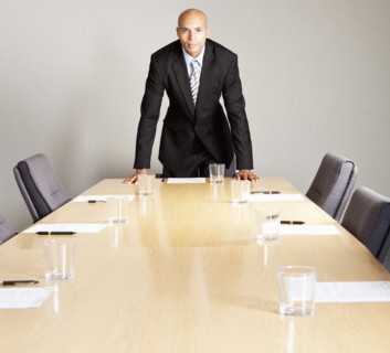 Mixed race businessman leaning on conference room table