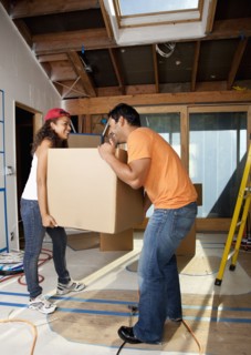 Hispanic couple carrying cardboard box