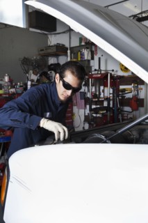 Hispanic mechanic working on car