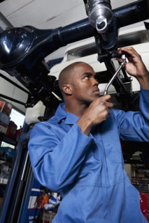 Black mechanic working on car