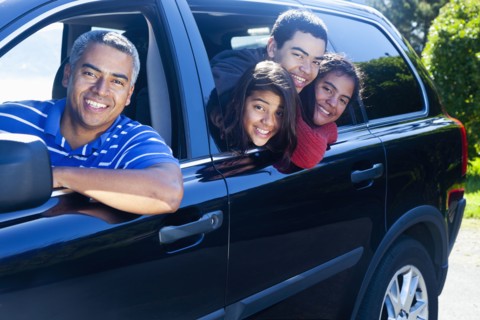 Hispanic family smiling in car