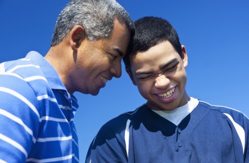 Hispanic father and son playing in park