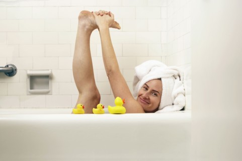 Caucasian woman playing in bath